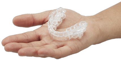 Closeup of an extended right hand, holding a clear obstructive sleep apnea mouthguard.
