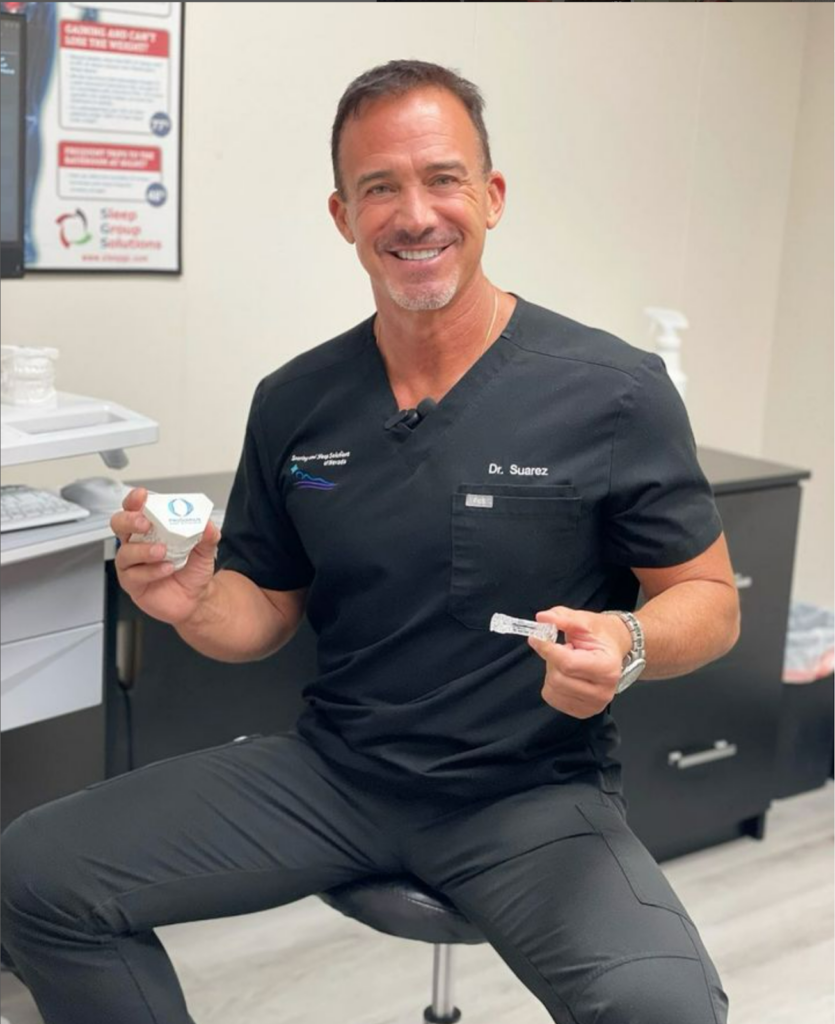 Dr Gill Suarez holding a couple of oral appliances that help with Obstructive Sleep Apnea that he recommends to his patients.