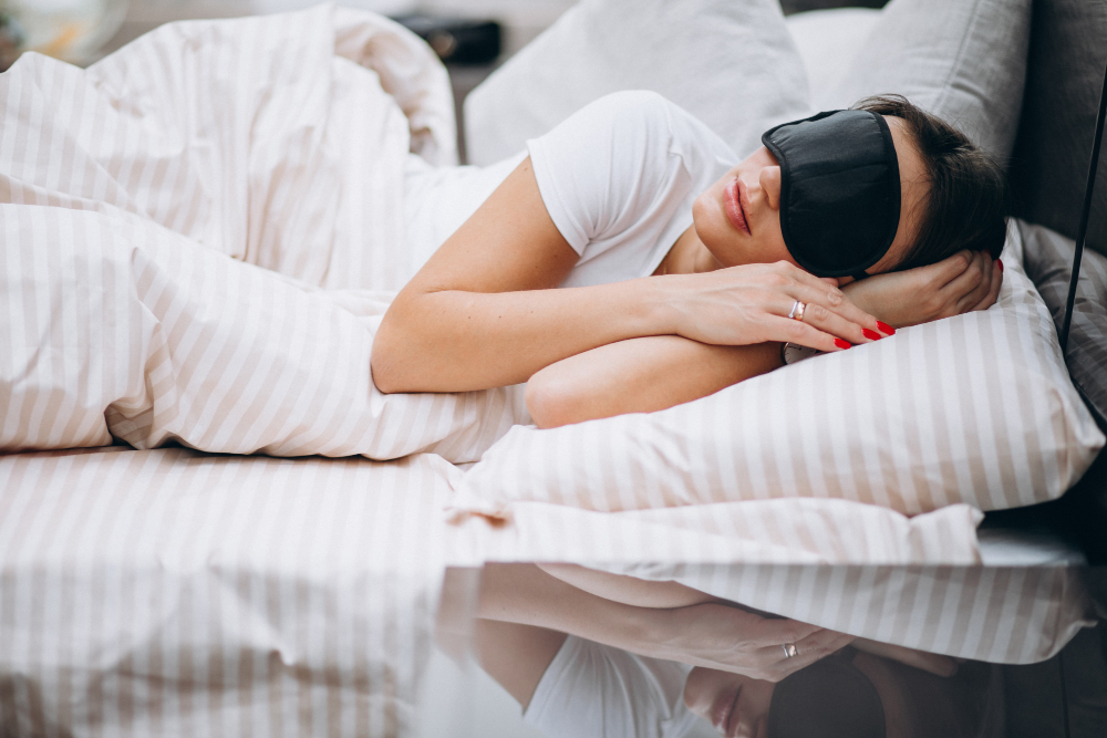 A woman sleeping with an eye mask